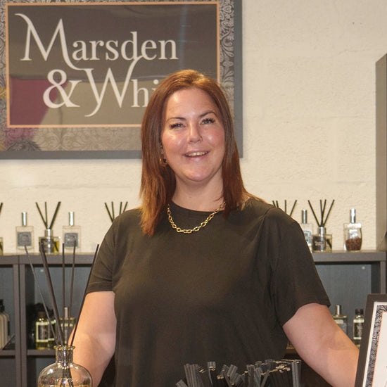 Woman standing behind a counter with products in a store named 'Marsden & Whittle'