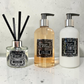 A Lime, Basil & Mandarin Reed Diffuser, Hand & Body Wash and Hand & Body Lotion sitting on a white marble surface with a white marble splash back behind.