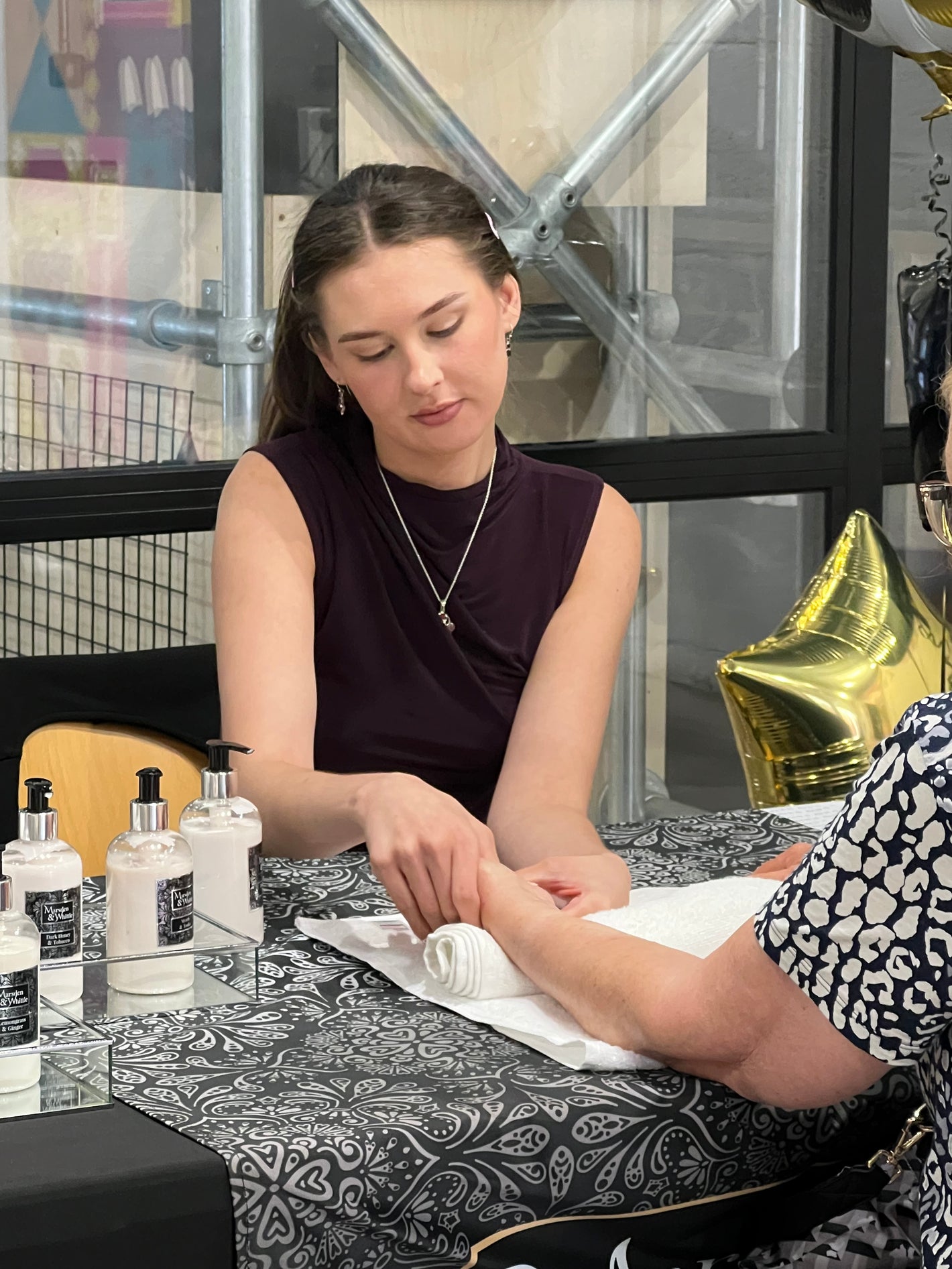 A customer enjoying a hand and arm massage at the Marsden & Whittle home fragrance shop inside Chapter Court at Wrexham City Centre.