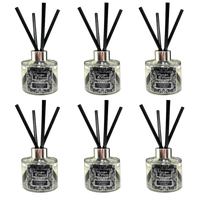 Six reed diffusers arranged in a 3-by-2 grid on a plain white background. Each diffuser has a clear glass bottle with black liquid, a silver-toned collar, a black decorative label, and multiple black reed sticks extending upward.