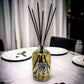 Diffuser bottle with black sticks on a table setting