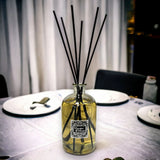 Diffuser bottle with black sticks on a table setting